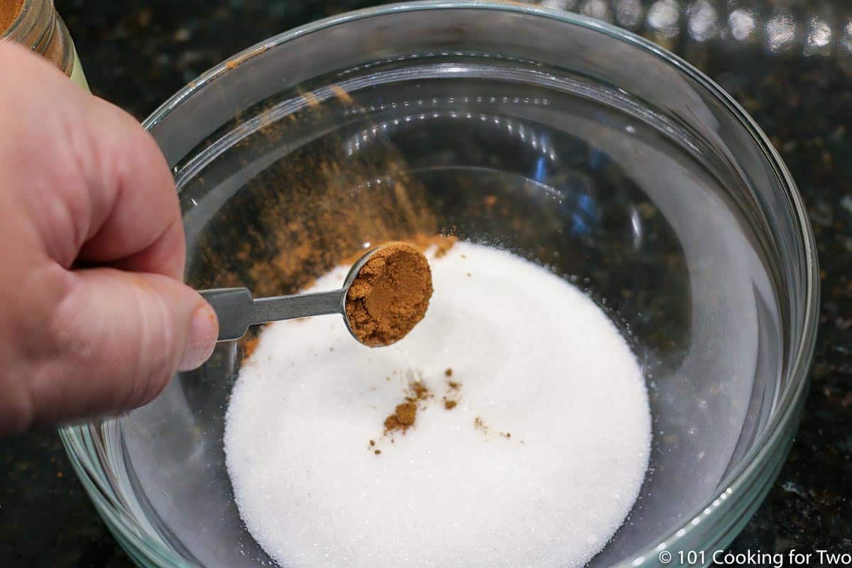 adding cinnamon to sugar in a small bowl.