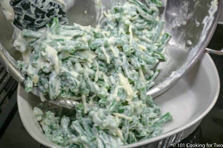 adding coated green beans into casserole.