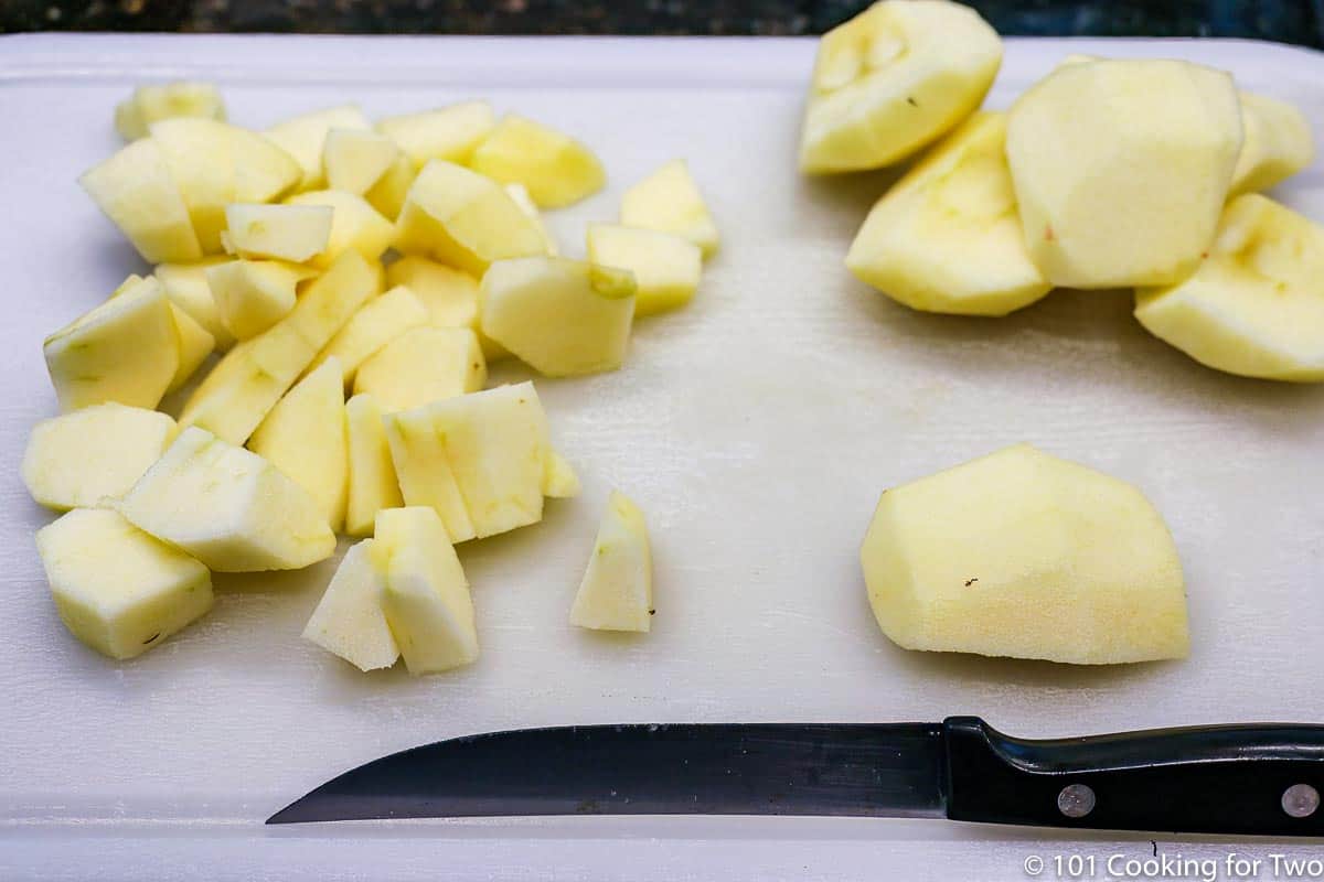 cutting up apples on a white board.