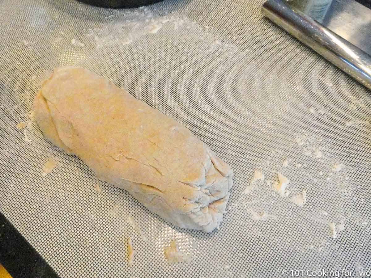 dough in a roll on a baking mat.