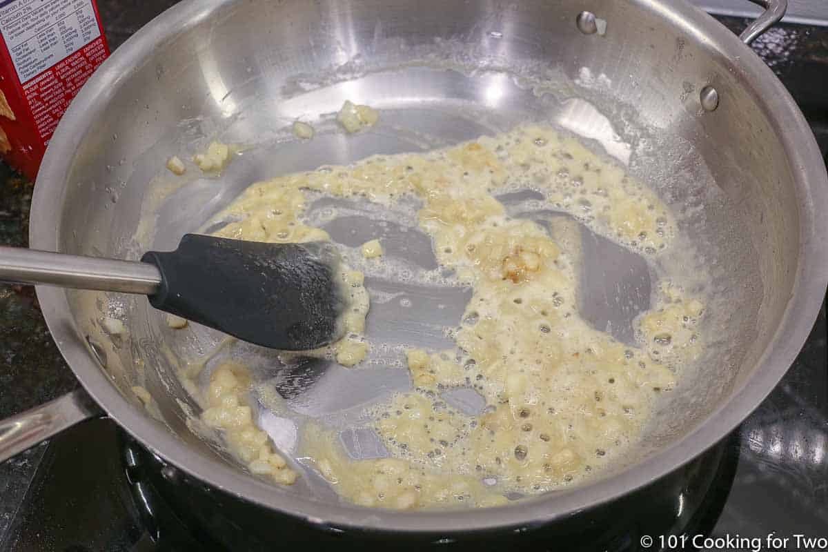 mixing a roux in a frying pan.