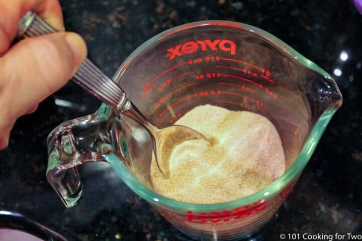 mixing sugar and cinnamon in a mixing bowl