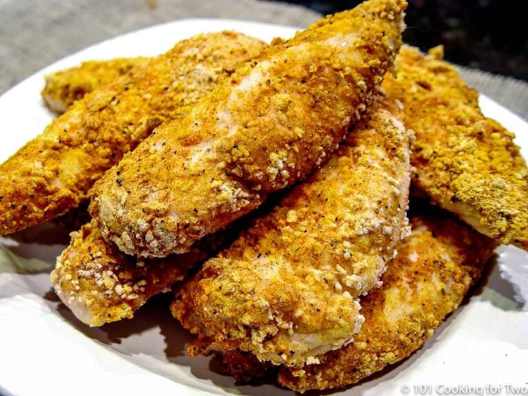 pile of chicken tenders on a white plate wide