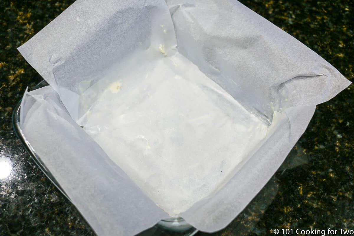 preparing a pan with crossed parchment paper.