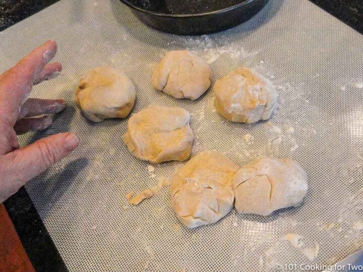 six pieces of dough on a baking mat