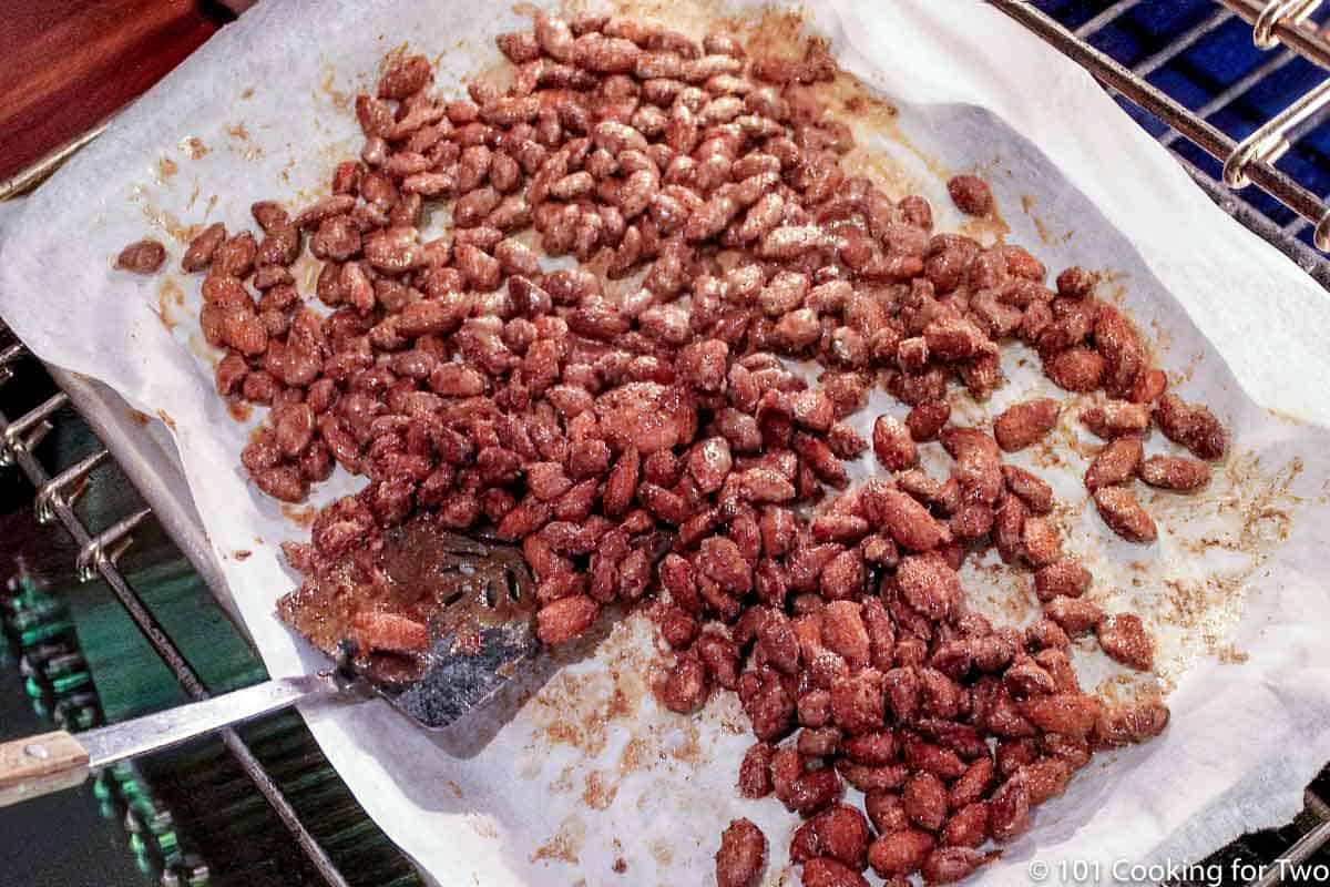 stirring nuts on tray with a spatula.