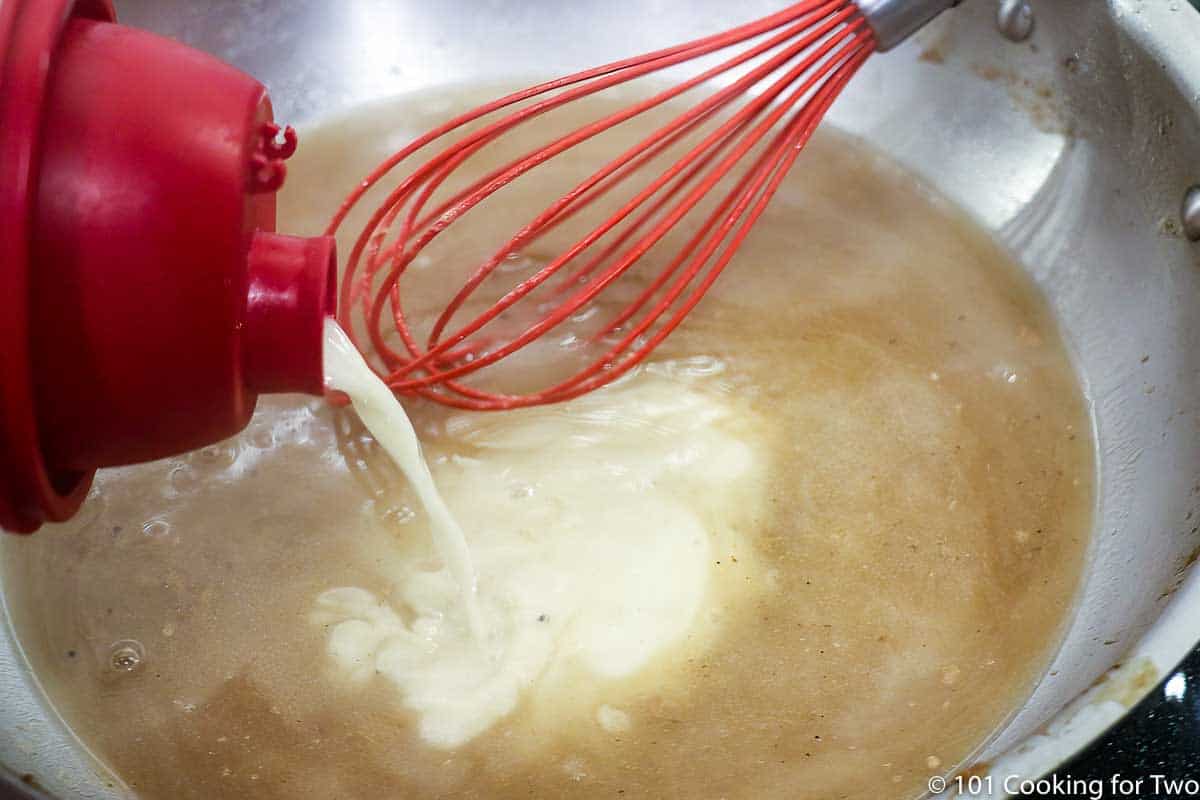 adding flour mixture to liquid in pan to make gravy.