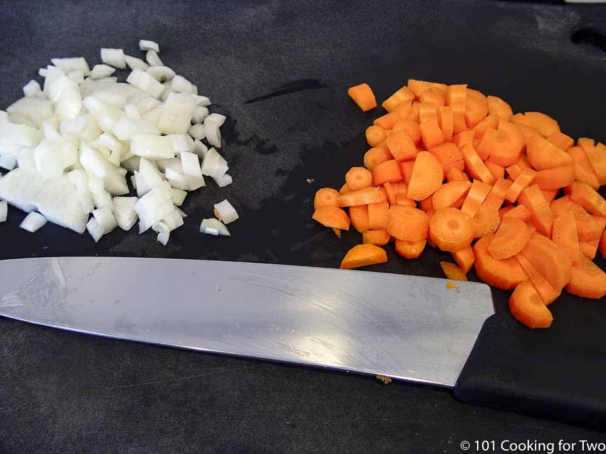 chopped onion and carrot on a black board