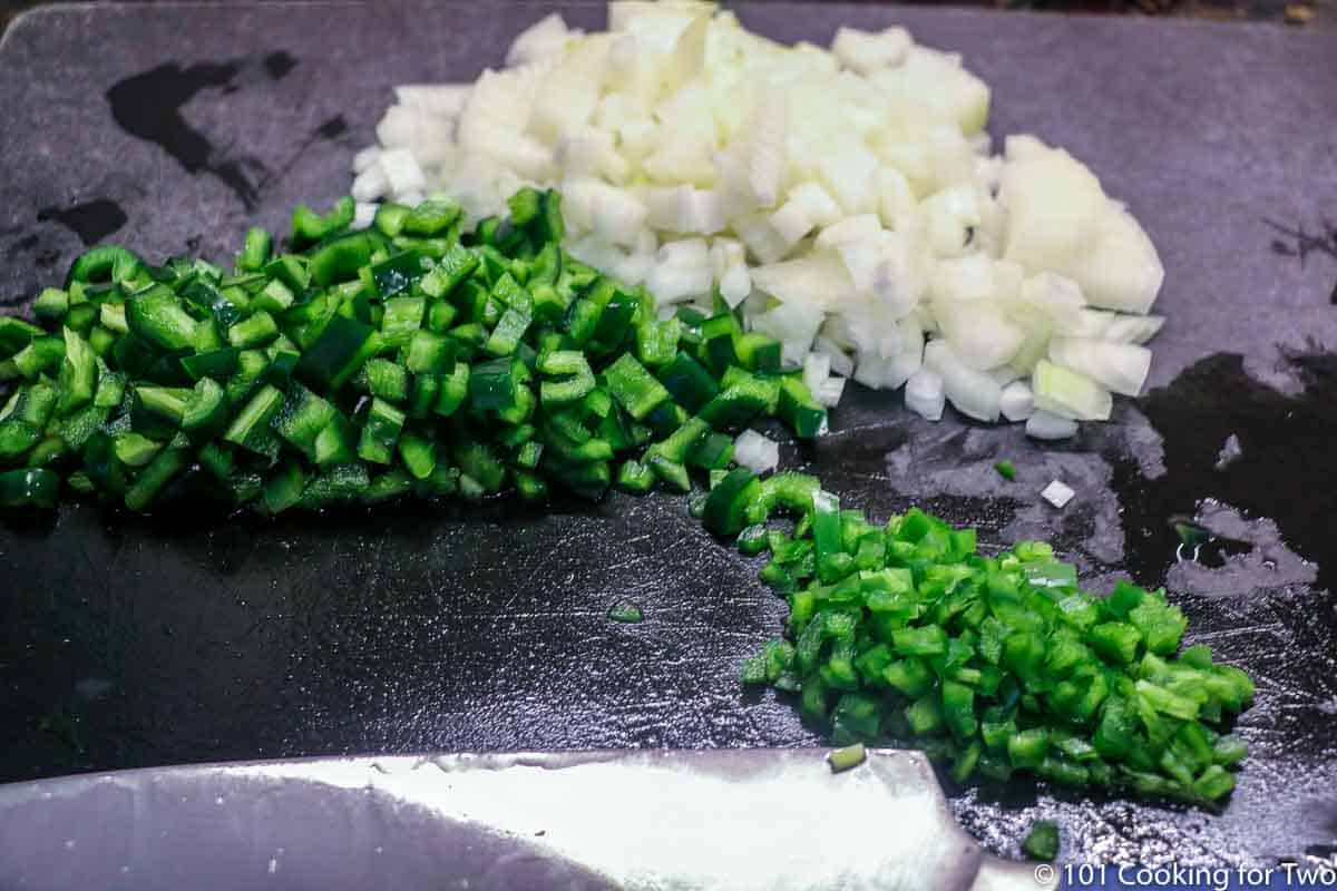 chopped peppers and onion on black board