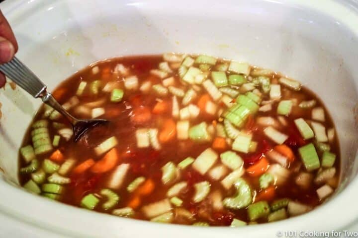 chopped vegetables with broth in a crock pot