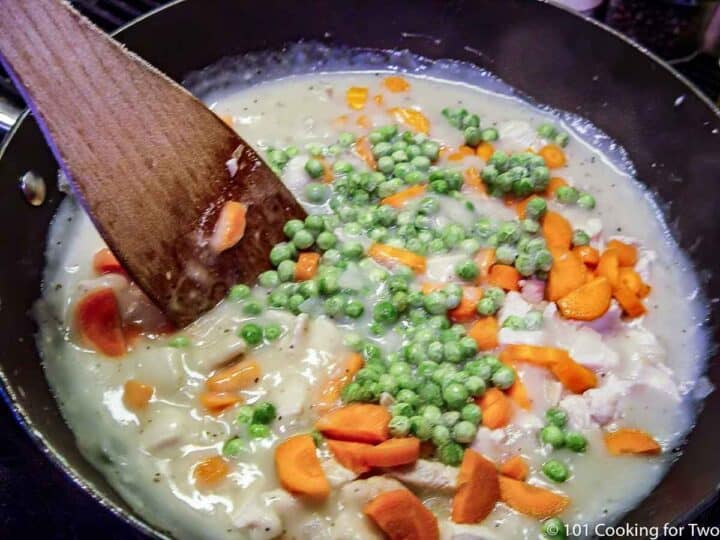 cooking chicken with carrots and peas in gravy