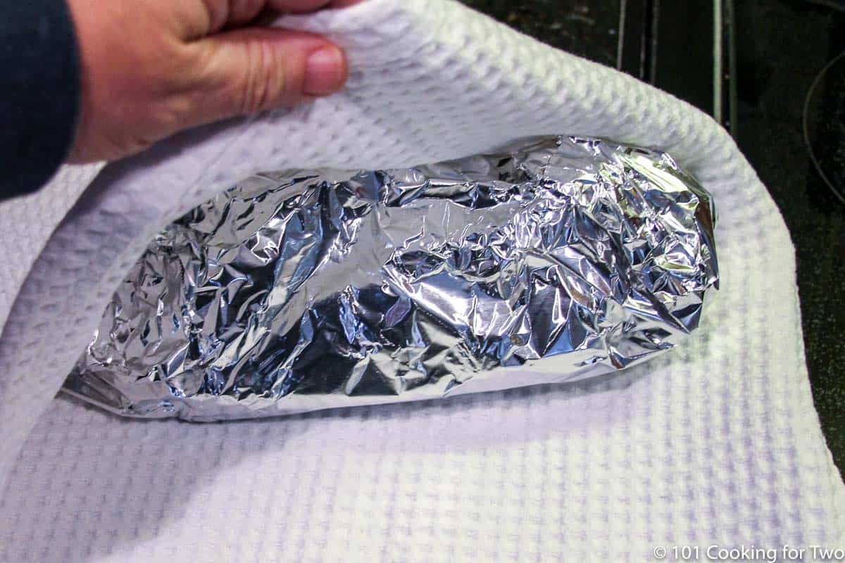pork butt in foil being wrapped