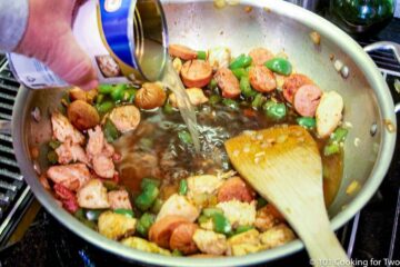 pouring broth into the pan with cooked veggies and meat