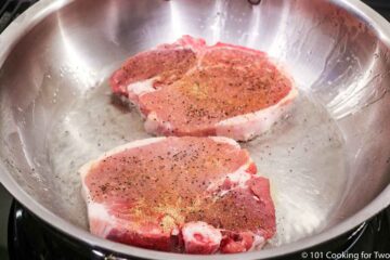raw pork chops in a pan with hot oil