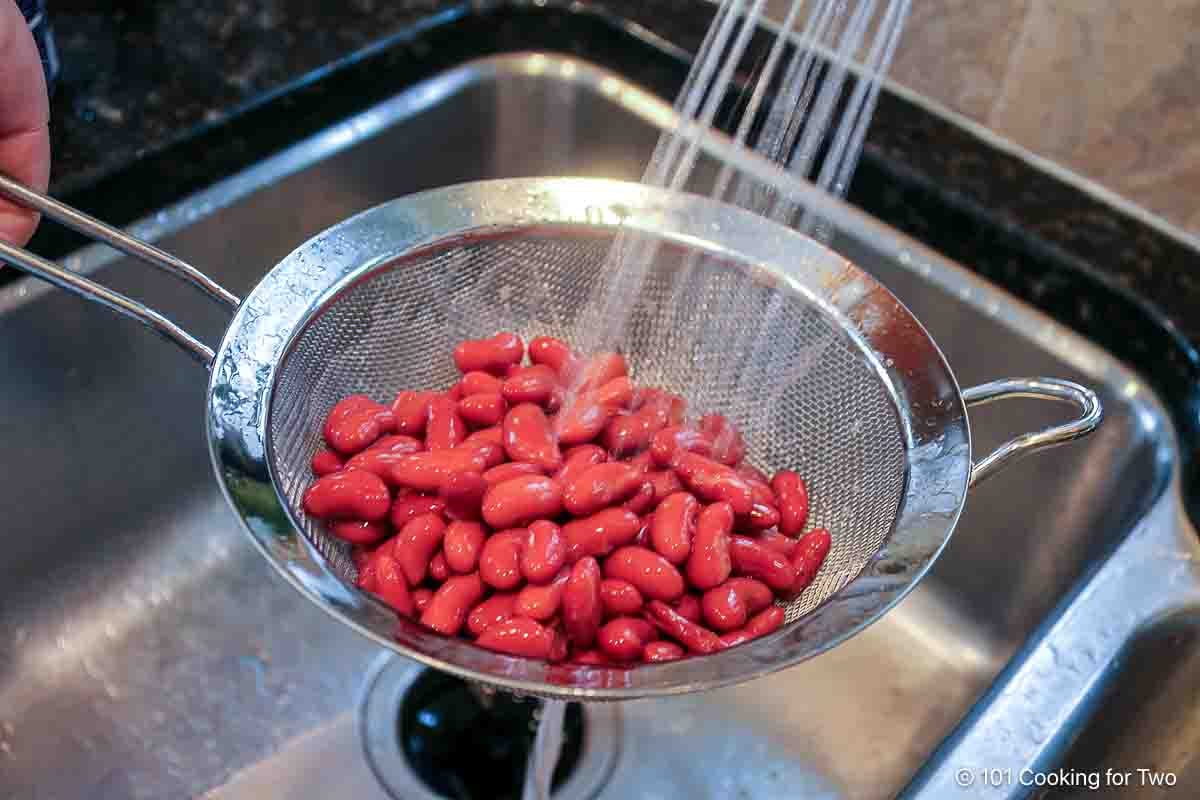 Rinsing red beans under running water.