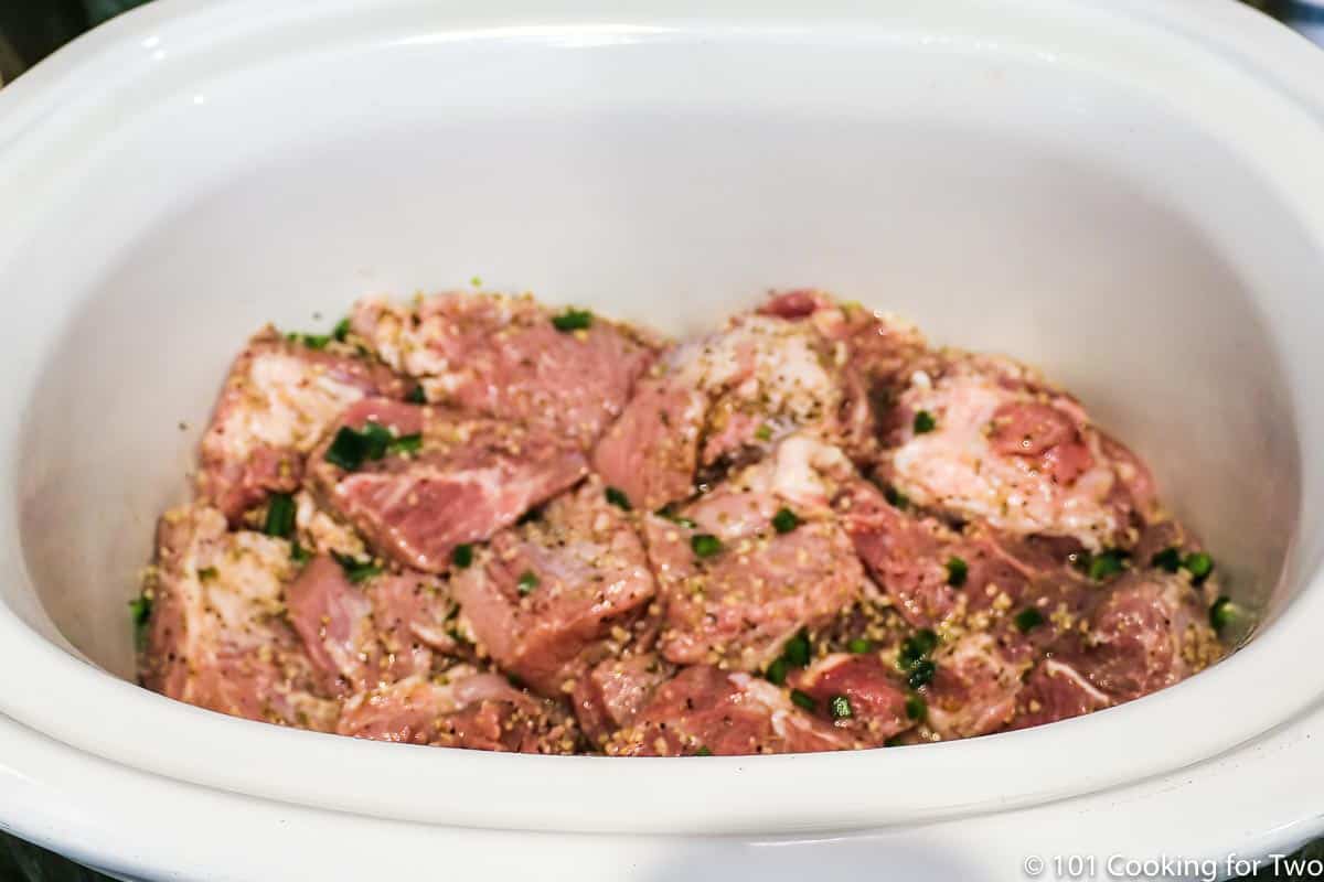 seasoned carnitas in a large crock pot.