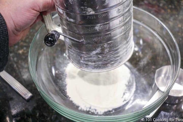 sifting flour into glass bowl