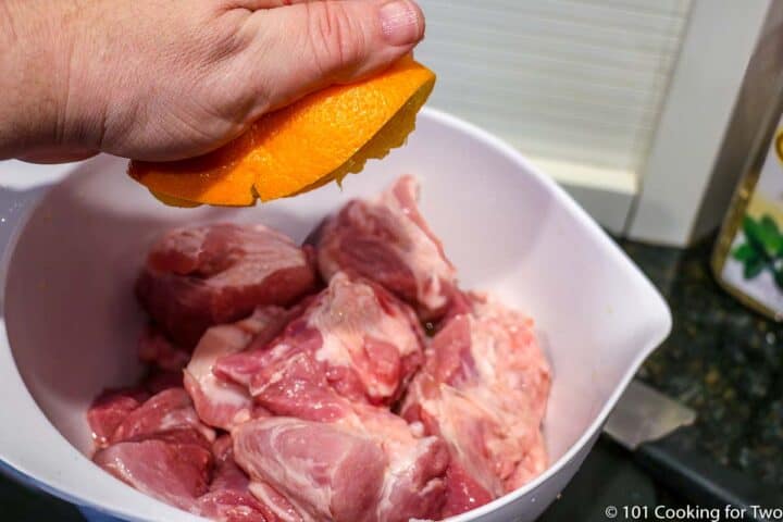 squeezing an orange on raw pork
