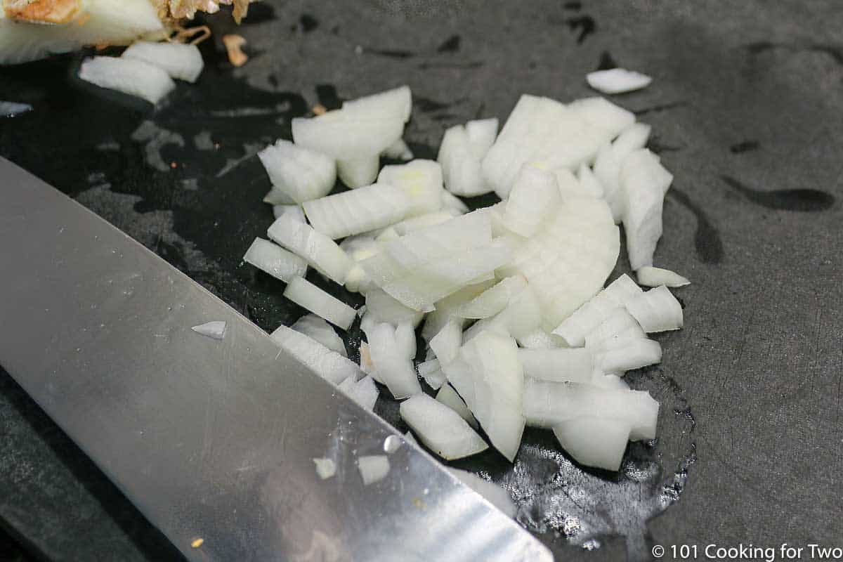 chopped onion on a black board.