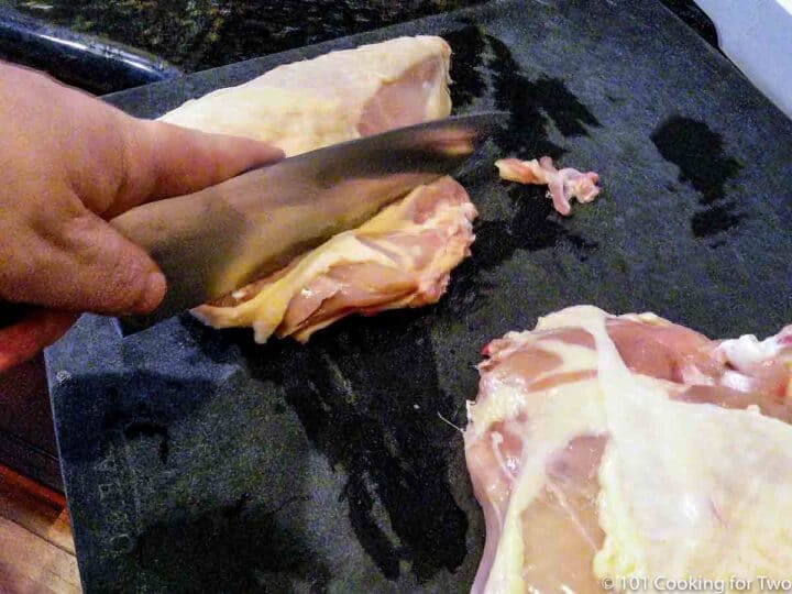 cutting off the rib section from split chicken breasts