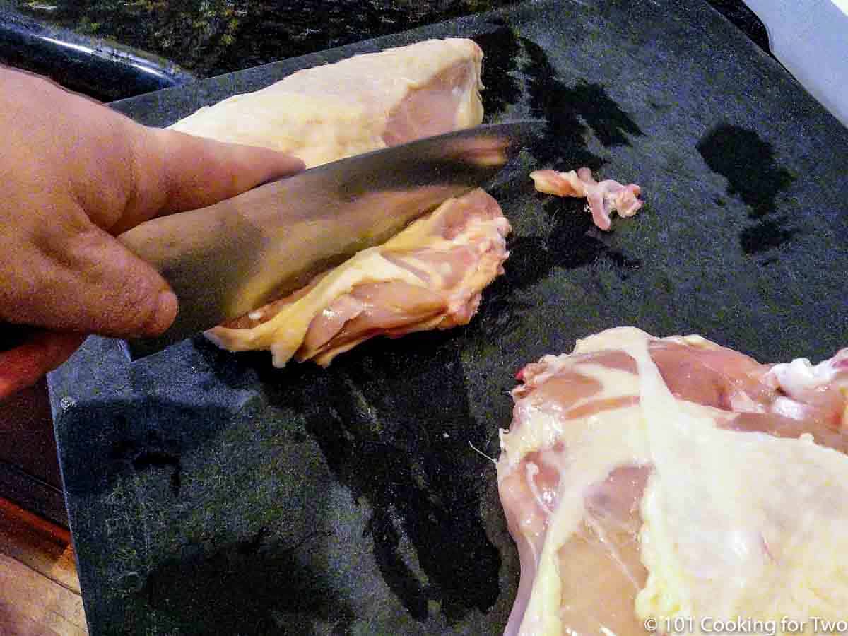 cutting off the rib section from split chicken breasts