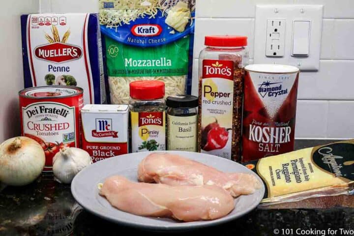 raw chicken with pasta and sauce ingredients