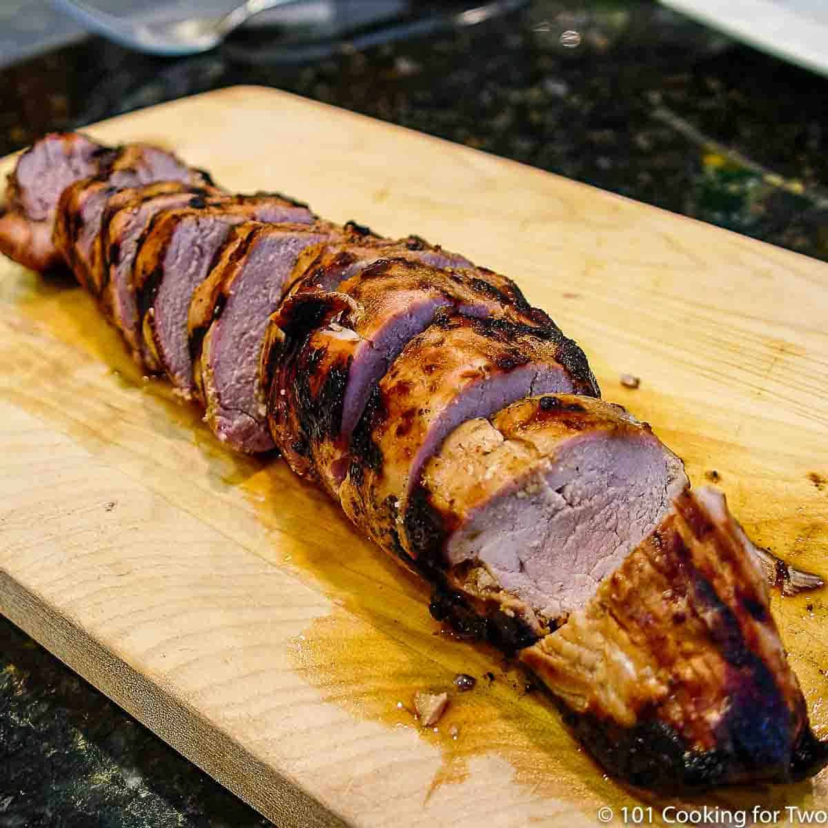 sliced pork tenderloin on a wooden board.