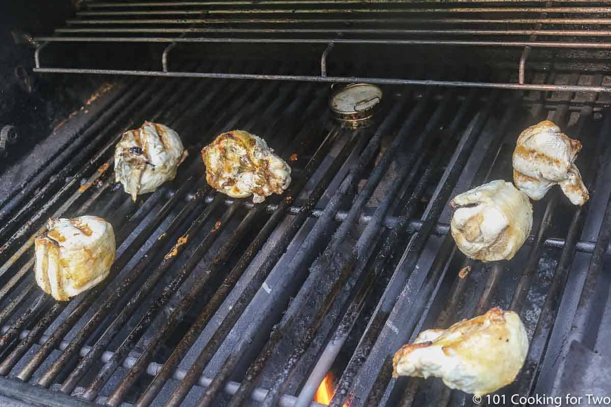 split chicken breasts on a gas grill surface