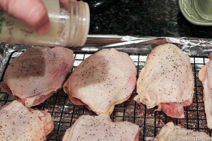 sprinkling chicken thighs with seaoning