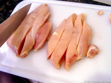 trimming chicken breasts on a white board