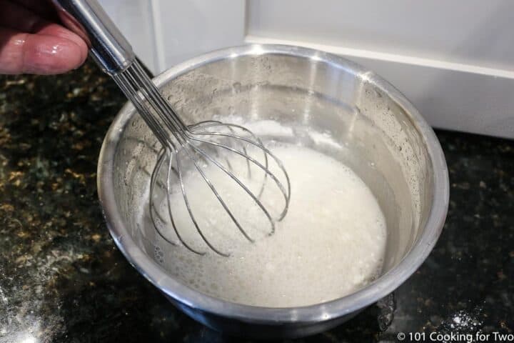 whisking flour into liquid in a small bowl