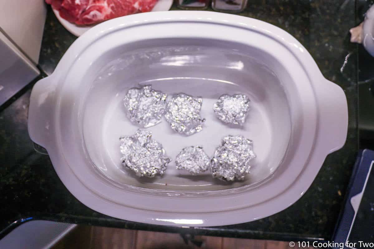 balls of foil in bottom of a crock pot.