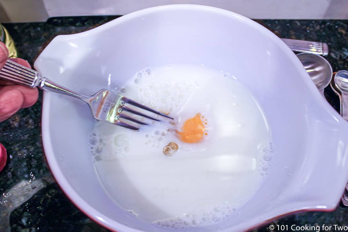 mixing an egg into milk.