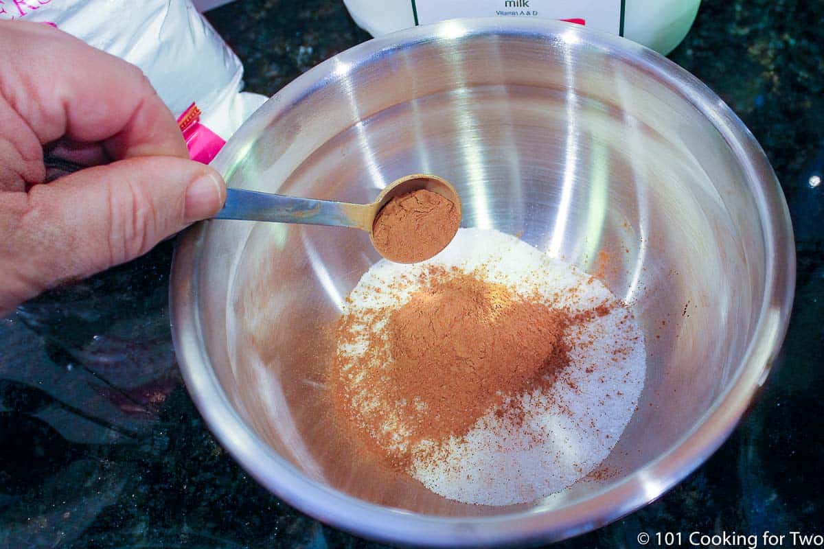 mixing cinnamon into sugar in small bowl.