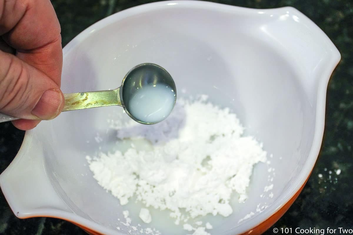 mixing glaze in a white bowl.
