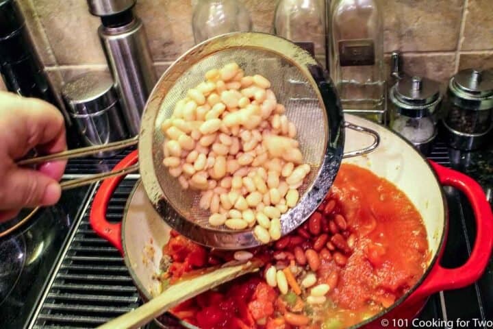 pouring rinsed beans into soup