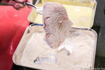raw pork chop on a fork covered with flour