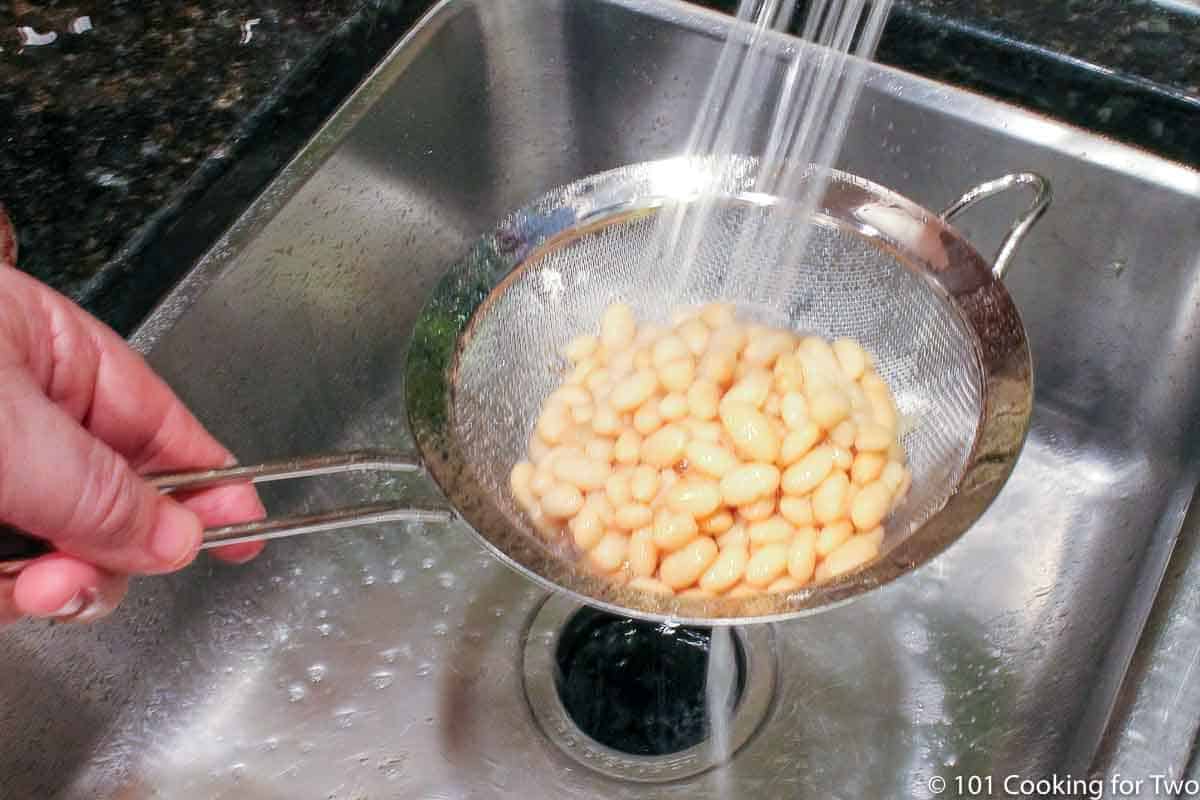 rinsing white beans under running water