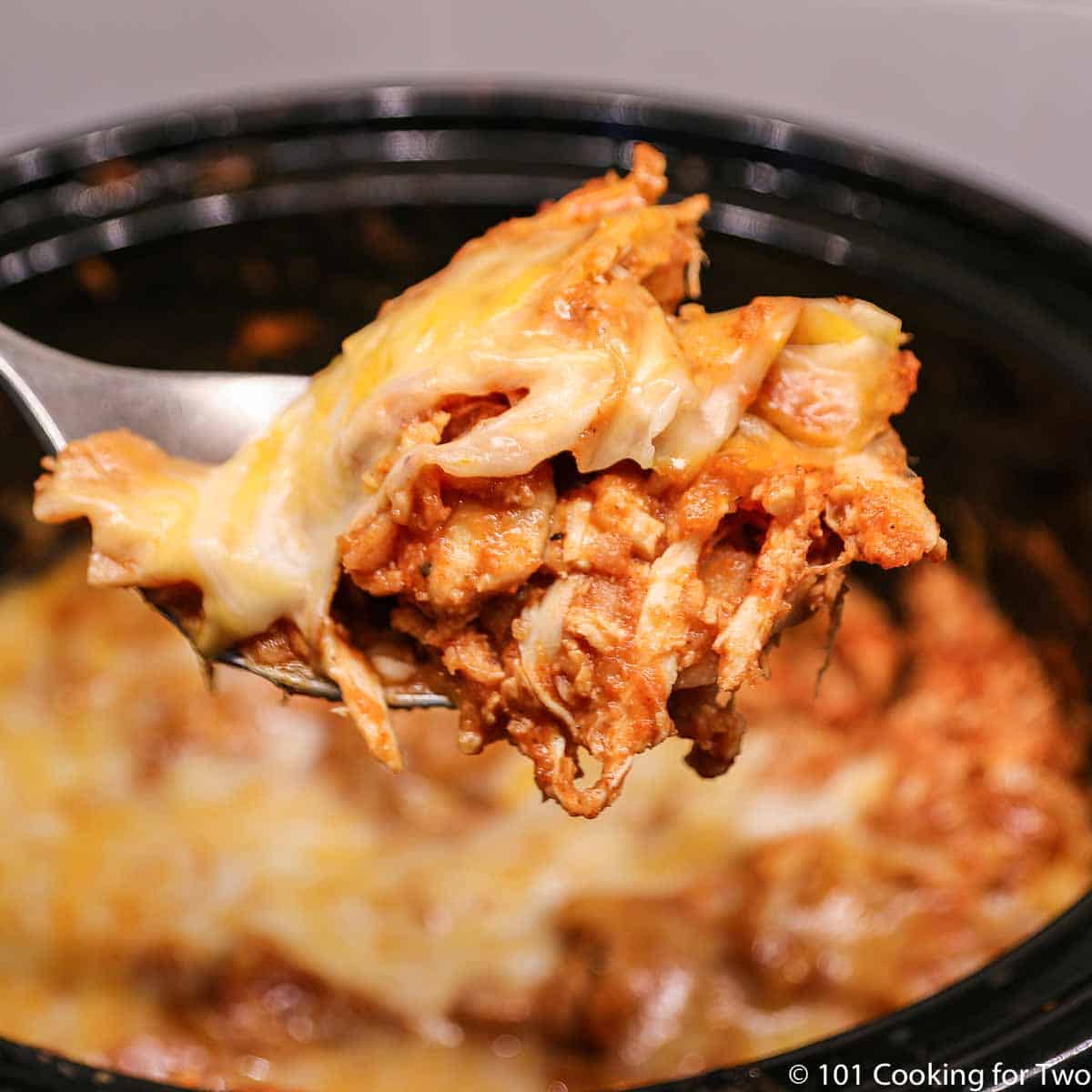 Chicken enchilada casserole on a large spoon