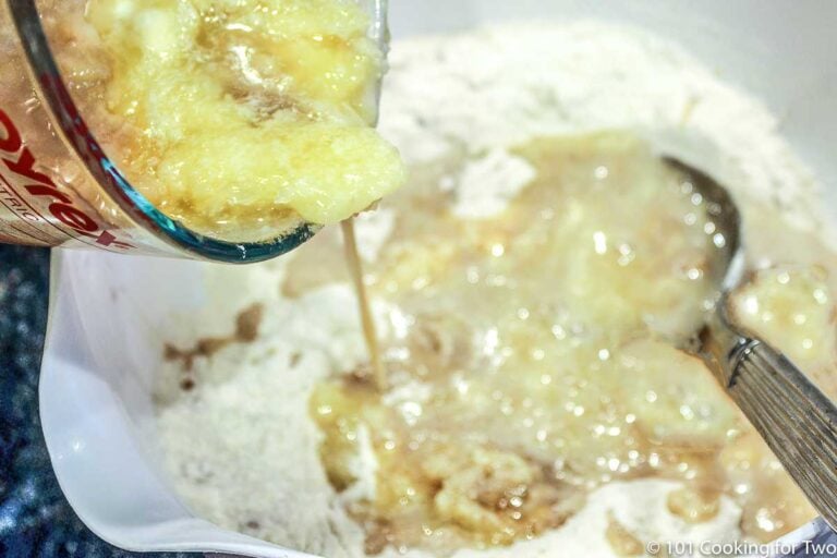 adding wet ingredients to dry in white bowl