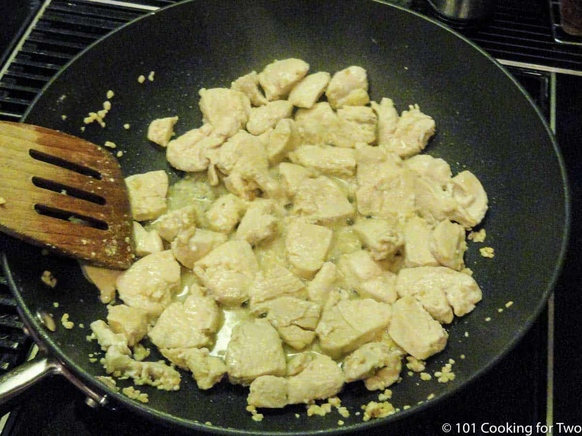 browning chicken in a black pan.
