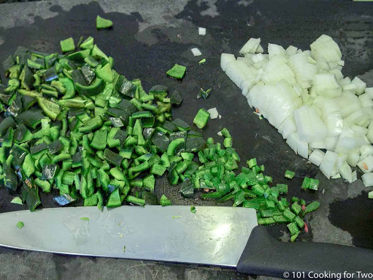 chopped peppers and onion on a black board