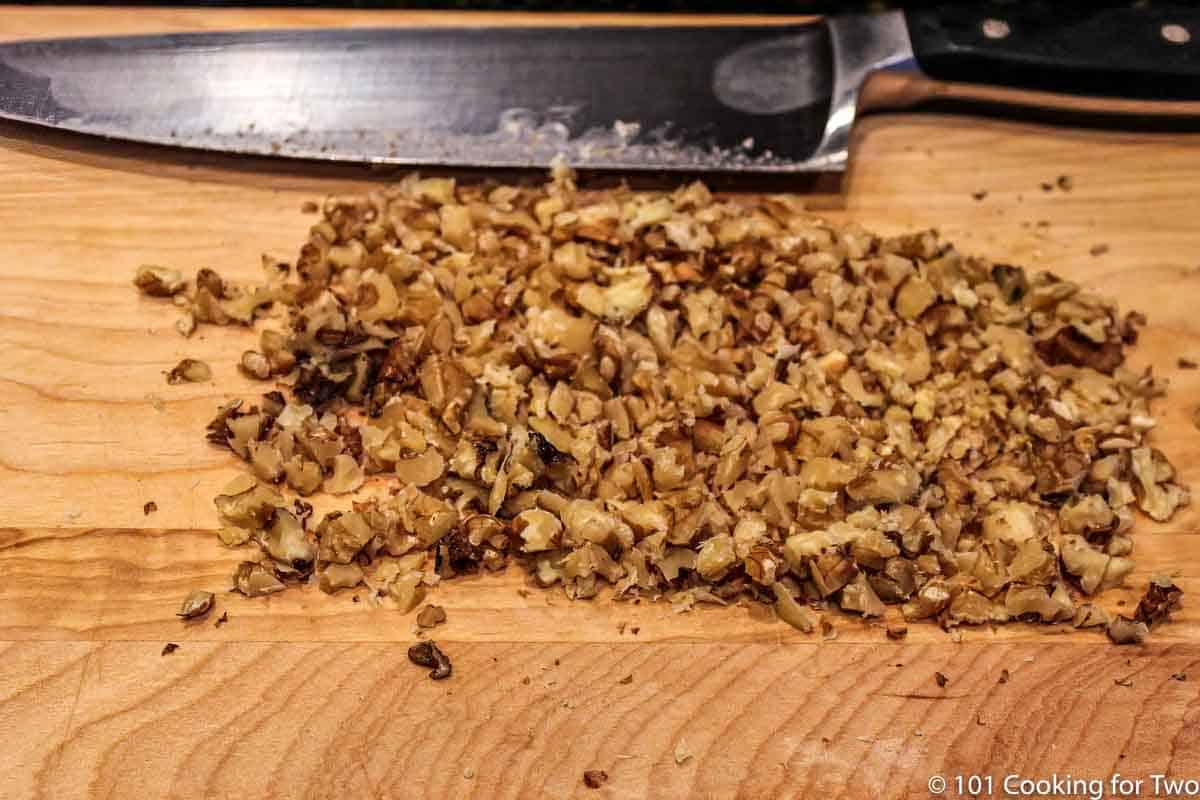 chopped walnuts on wooden board.