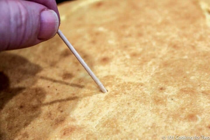 close up of toothpick coming out of cornbread clean.