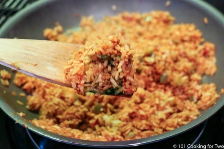 cooked Mexican rice on a wooden spoon