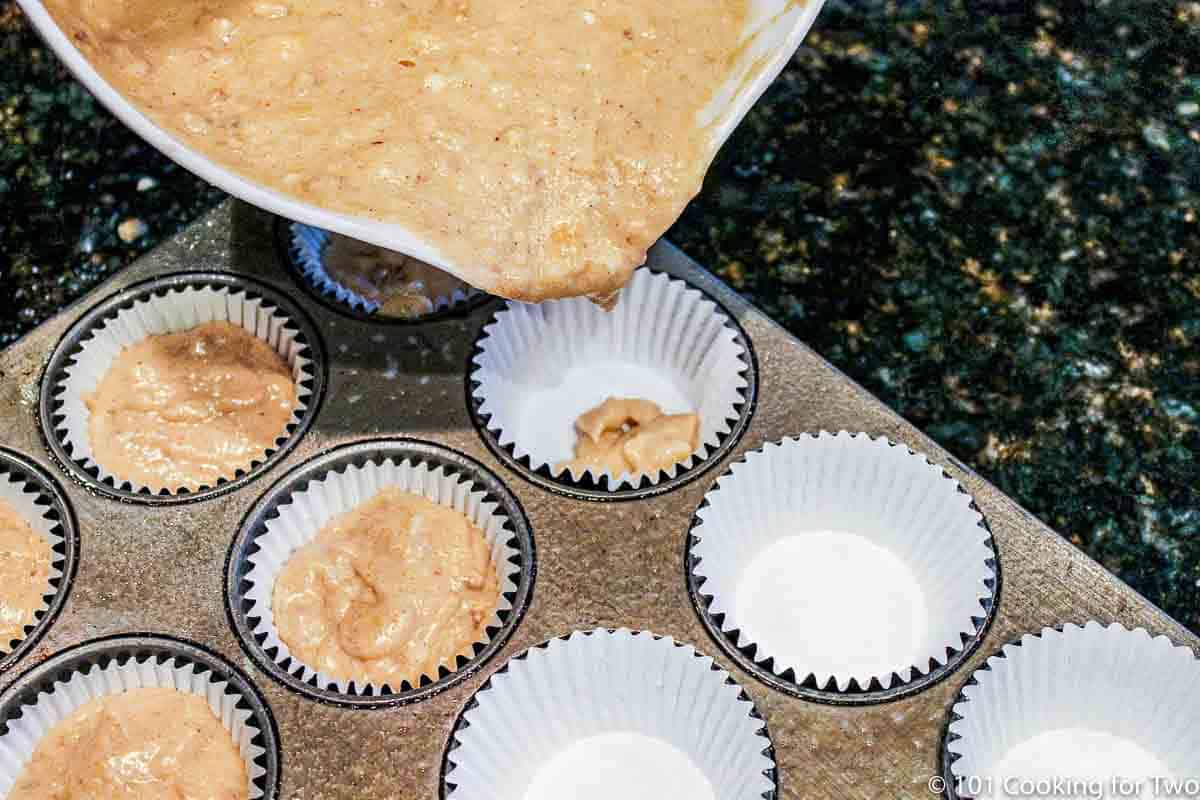 filling muffin tin with batter.