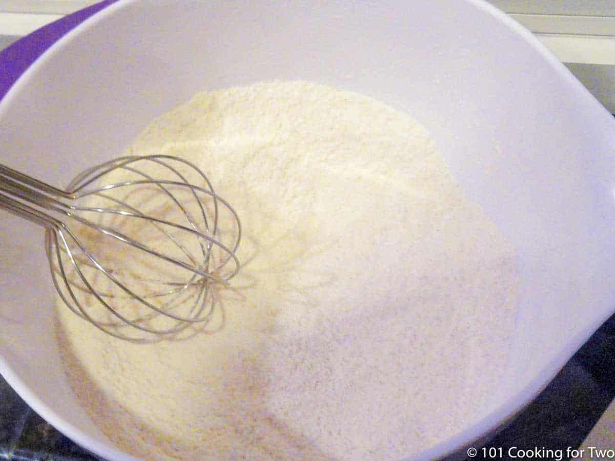 mixing dry ingredients together in white bowl.