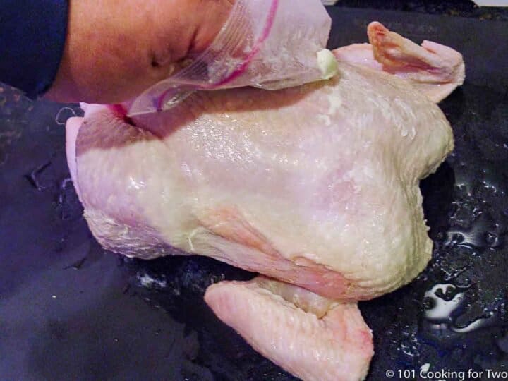 rubbing butter onto a whole chicken