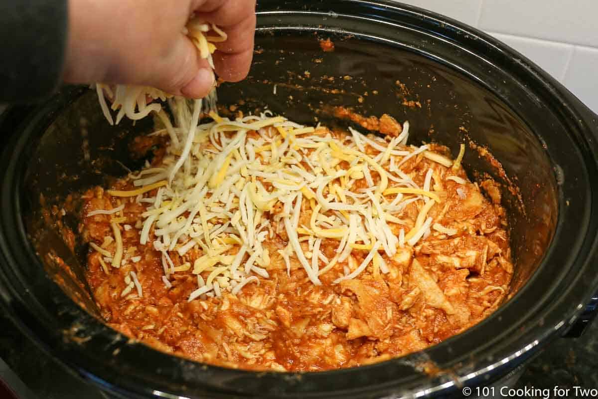 topping the casserole with shredded cheese.