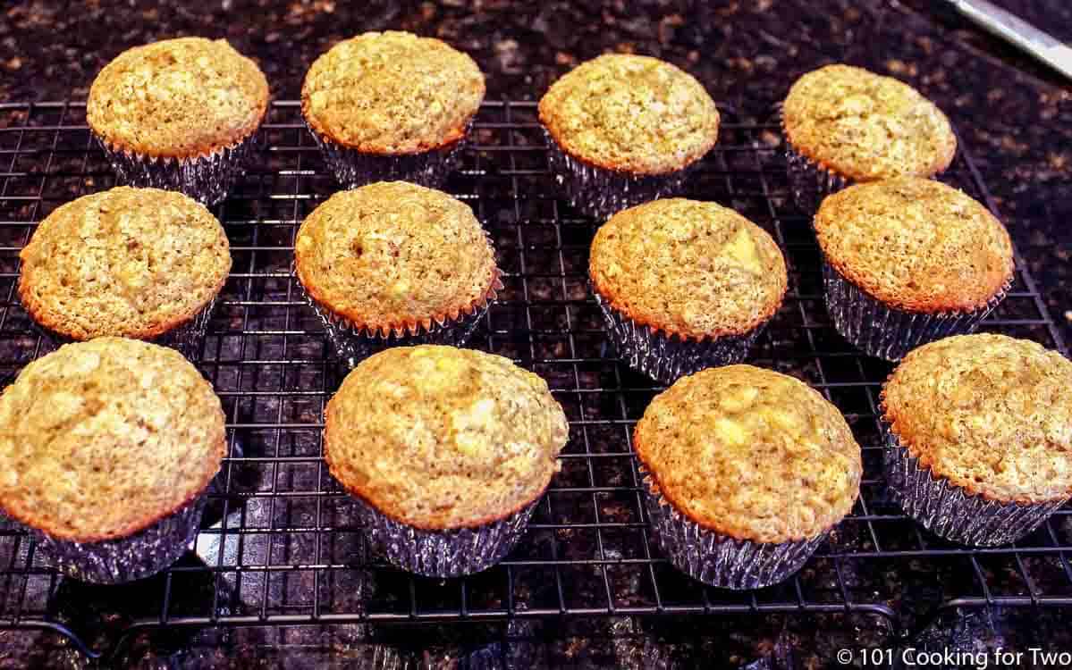 twelve baked muffins on a wire rack.